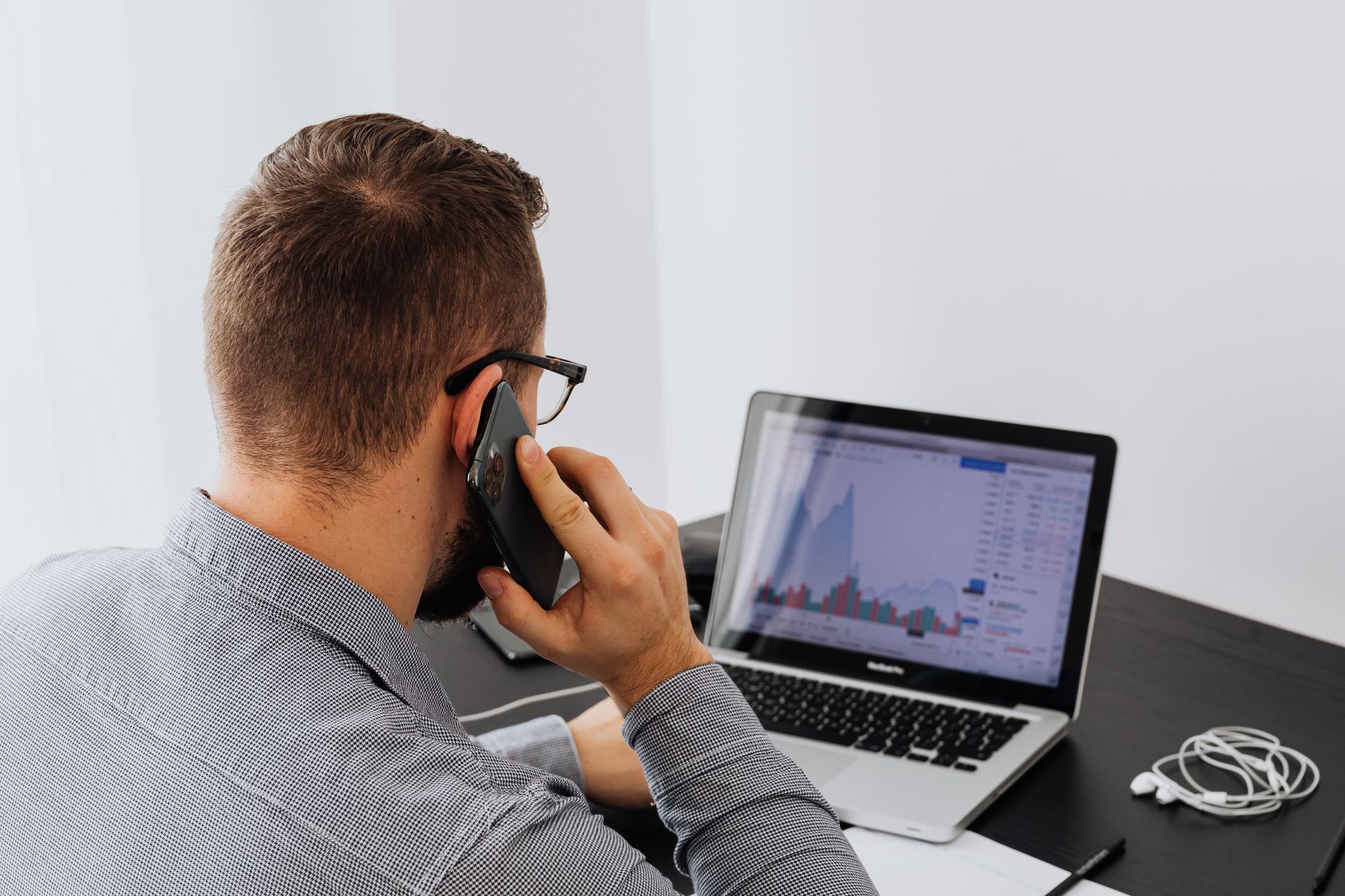 A trader reviewing a prop challenge offer on a laptop and phone, illustrating Meta ads for prop challenges