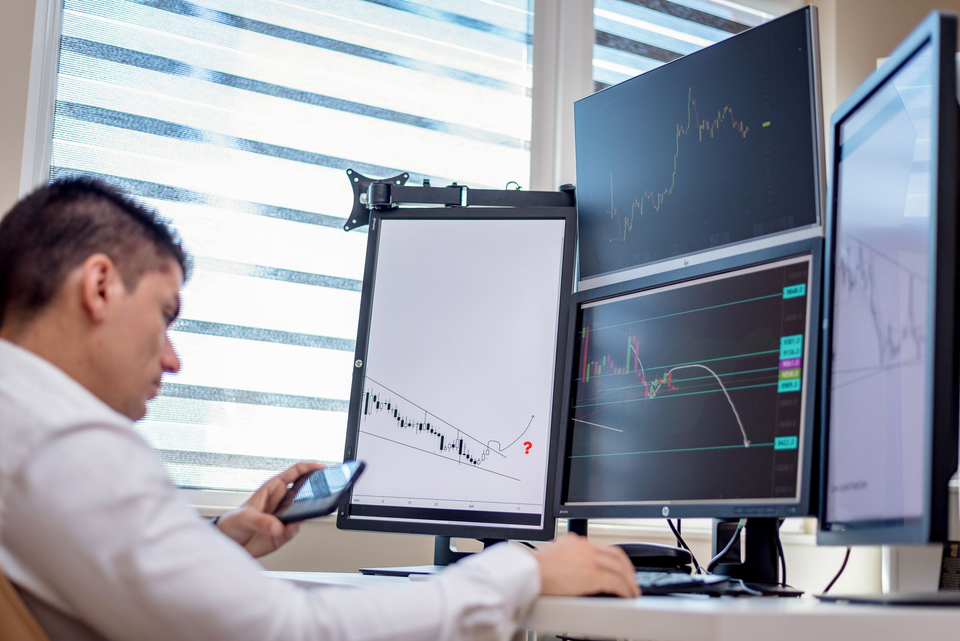 Phone displaying a trading dashboard beside a laptop, illustrating Meta ads for prop challenges
