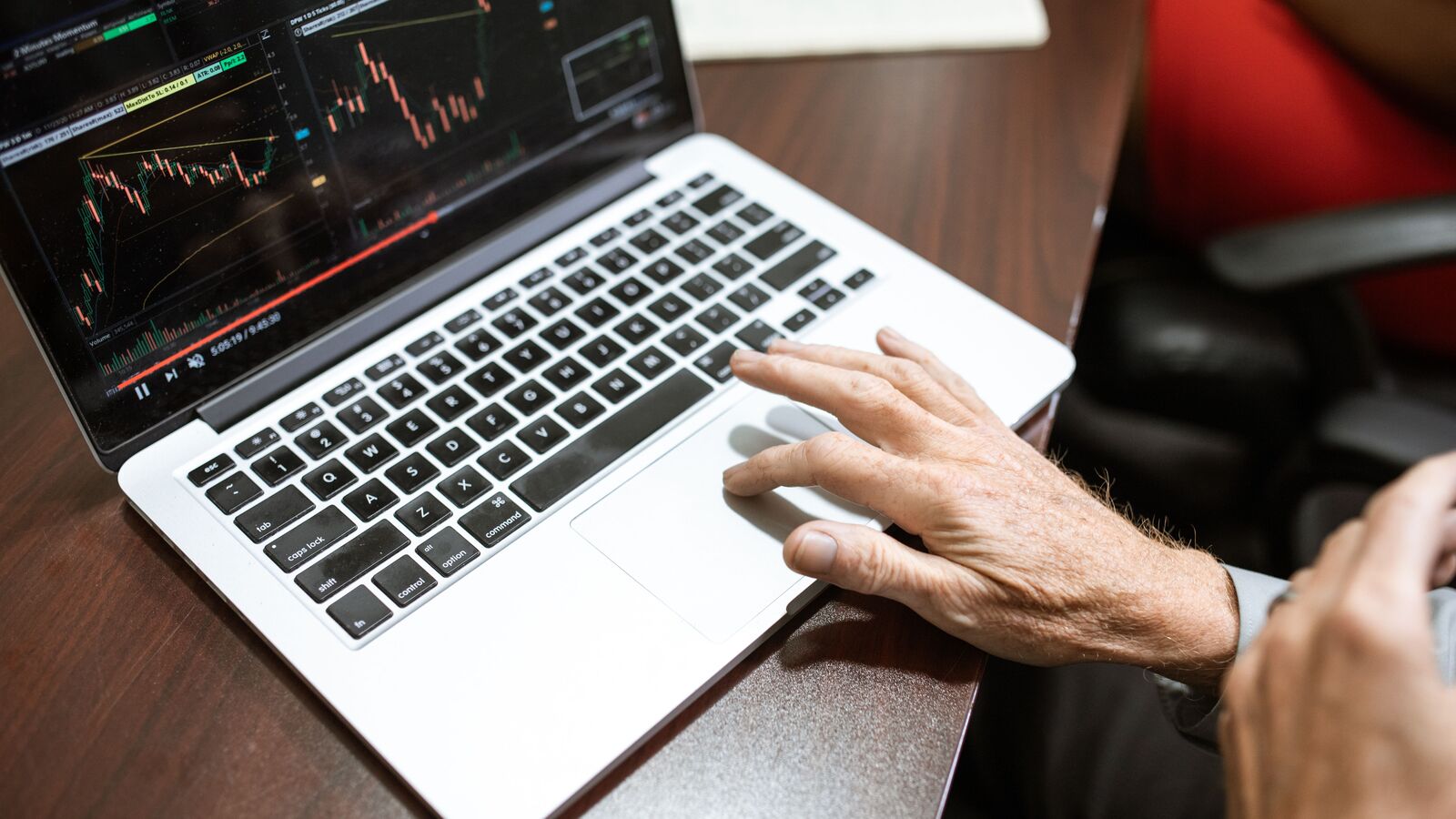 A desk with a laptop showing trading charts, used to illustrate prop firm marketing agency costs